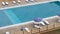 Top view of the pool with blue water and sun loungers and umbrellas