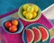 Top view of poolside party table with fresh, juicy fruit served on retro ceramics