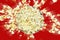 Top view popcorn explosion on red background.