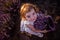 Top view portrait of little girl sitting in field among rows, collecting bouquet of purple lavender