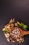 Top view portrait shot of herbal medicines in a wooden spoon with natural herbs on a black background and copy space. Ayurveda