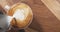 Top view pour steamed milk into cappuccino on wood table