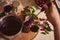 Top view of pouring freshly brewed cherry jam from metal saucepan into sterilized glass jars. Preparations and conservation for