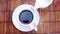 Top of view of pouring stream milk into a cup of espresso on a wooden table.