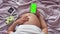 Top view, pregnant girl`s belly, which she is stroking with her hand. A pregnant girl is lying on the bed holding a