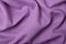 Top view of purple linen fabric with folds. Empty space for design