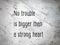 Top view of a quote on concrete background.  No trouble is bigger than a strong heart.