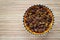 Top view raisins in a bowl on a wooden table