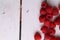 Top view of raspberries arranged on one side on a white wooden table