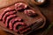 Top view of raw beef ribs and loin in small pieces, with salt and green seasoning, on textured wooden background with space for