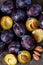 Top view on raw plums on wooden table background