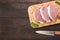 Top view raw pork chop steak on cutting board and knife on wooden background. Copyspace for your text