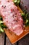 Top view on raw pork meat with pepper and salt on chopping board