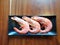 Top view of raw shrimps in black plate on wooden table in restaurant