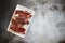 Top view of raw steak pieces in a plate on a gray surface under the lights