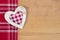 Top view of red checkered heart shape on a wooden old backgroun