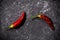 Top view of red fresh and dried small chili peppers on black stone background. the concept of penis, potency and impotence, drugs