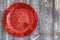 Top view red hand-painted plate on wooden surface