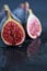 Top view of the red interior of a fig, reflected in water, with more unfocused figs
