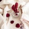 Top view red painted dried thistles and berries on a white knitted sweater