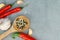 Top view of red pepper pods, head of garlic, wooden spoon with allspice