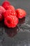 Top view of red raspberries, the first focusing the other out of focus, on water and blackboard background