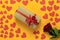 top view of a red rose lies on a yellow background. Lots of red cardboard hearts of different sizes. box packed in craft