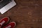 Top view of red suede sneakers and opened laptop standing on brown wooden planks