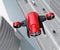 Top view of red VTOL drone carrying delivery packages flying over highway bridge