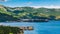 Top view of resort Budva with hotels and beaches and boats with ships sail from coast to coast along bay in sunlight