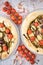 Top view of a restaurant table with delicious pizza, brown olives, tomatoes, and spices