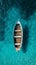 Top view of a retro fishing boat in blue clear ocean. Shade from the sun's rays. Ocean still life concept