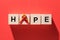 top view of ribbon and lettering hope from wooden cubes on red background world hepatitis