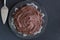 Top view of rich chocolate cake on glass plate with server on bl