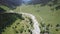 Top view of a river in the mountains on a sunny day. Top view wild river flowing between green mountains on a clear