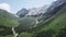 Top view of a river in the mountains on a sunny day. Top view wild river flowing between green mountains on a clear