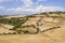 Top view of a road in Tuscany with farm fields, houses and blue sky, Italy