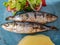 Top view of roasted sardine with salad and boiled potatoes