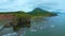 Top view of rocky coast with algae on shore. Clip. Landscape of rocks on coast with algae on background of mountains in