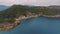 Top view of a rocky shore covered with green trees. Cave in the rock. Blue clear water. Seascape.