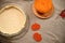 Top view of a rolled pastry dough in baking dish and fresh ingredients for making pumpkin apple Thanksgiving pie.