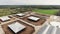 Top view on roofs of modern clean fenced farm with square paddocks for cows