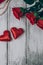 Top view of roses, gift box with bead and two red hearts on wooden background.