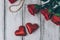 Top view of roses, gift box with bead and two red hearts on wooden background.