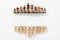 Top view of rows made of brown and beige wooden chess figures on white background with copy space.