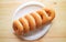 Top View of Rows of Sugar Glazed Doughnuts on White Plate