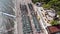 Top view of rows of sun loungers by the sea in a recreation area with tourists and a floating pier on the waves. Travel