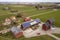 Top view of rural landscape on sunny spring day. Farm with solar photo voltaic panels system on wooden building, barn or house