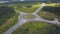 Top view of rural roundabout with traffic. Clip. Beautiful landscape of forest horizon and rural intersection of roads