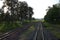 Top view of the rusty rails crossing the green field in a summer day , Northern Railway Thailand